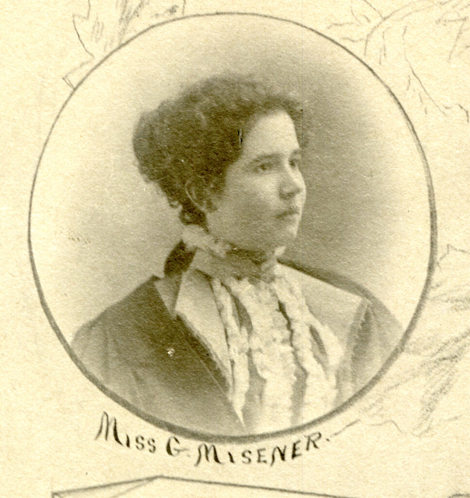 Senior portrait of a young white woman with dark hair wearing a high-collared dress. Text read “Miss G. Misener.” It is the senior photo of Geneva Misener from Queen’s University.
