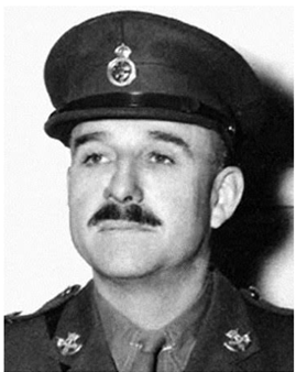 Commander Jim Stone shown wearing his military uniform. He is visible from the shoulders up and is looking to the right of the camera. He is a white man with a dark mustache.