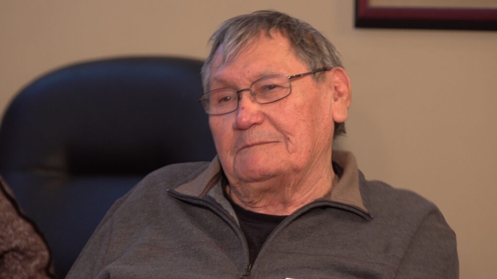 A photo of Tom Daniels, one of the ironworkers featured in Alvin Finkel's story Waltzing with the Angels. Here he is an older man with glasses, sitting in an office.