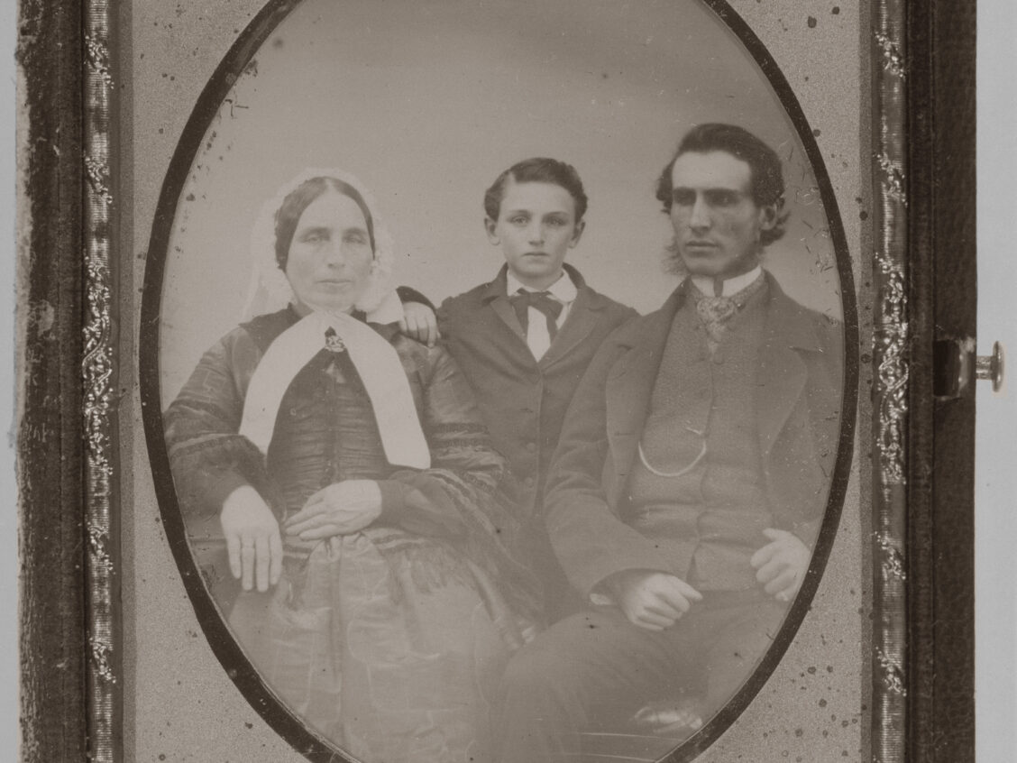 A daguerrotype of an older woman, a boy, and a young man.