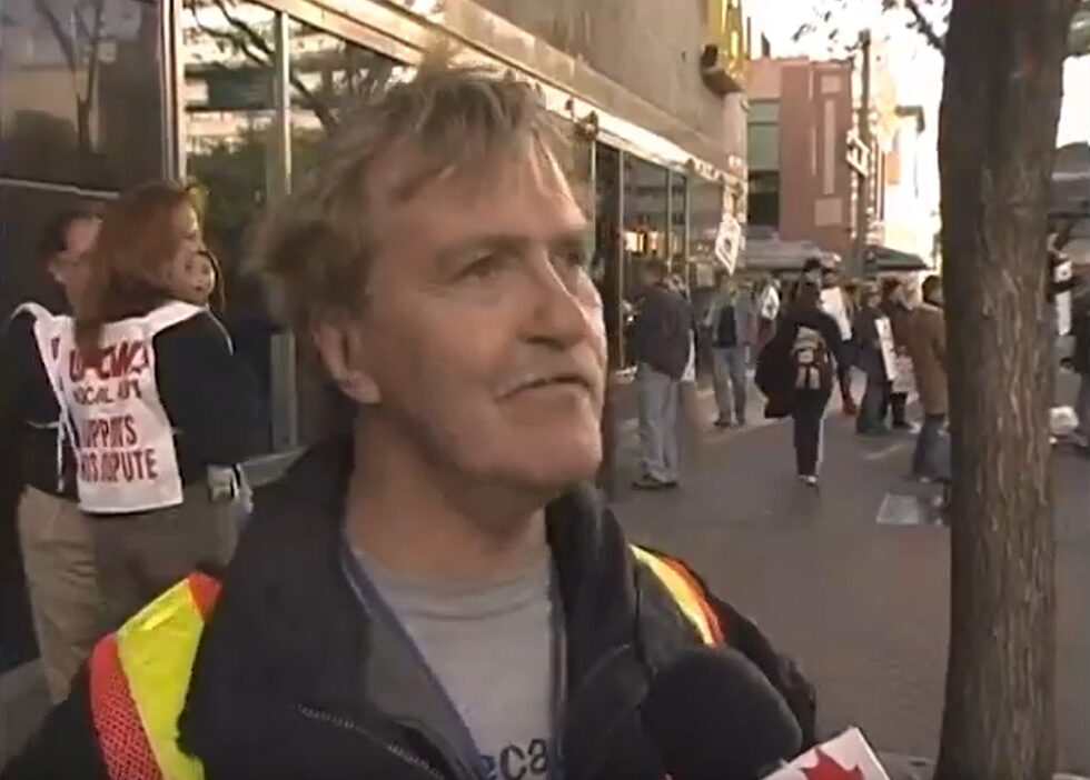 A man in a safety vest being interviewed on a street corner in front of A-Channel.